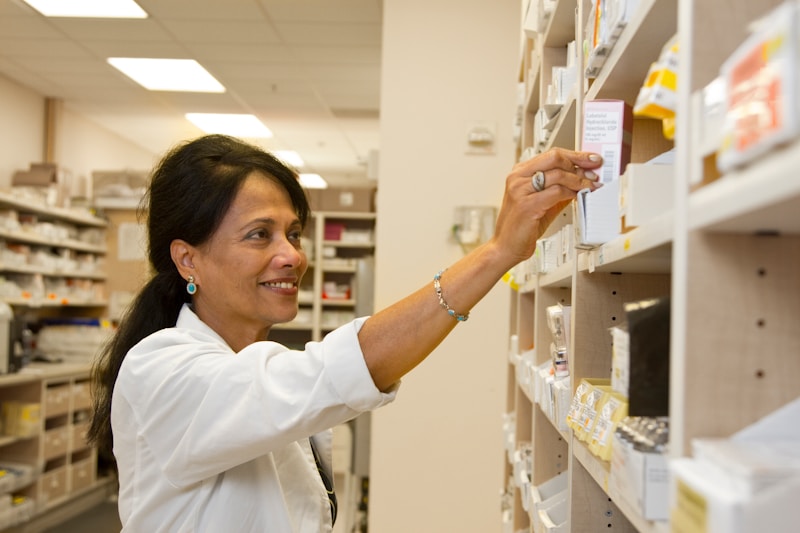 Community pharmacist selecting medication from pharmacy shelf. Photo: NCI / Rhoda Baer, public domain.